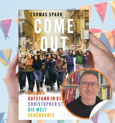 Sachbuch „Come Out!“ von Thomas Sparr in den Händen einer Person, mit Autorenporträt und Pride-Dekoration im Hintergrund.